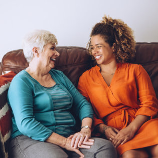 woman and elderly smiling at each other